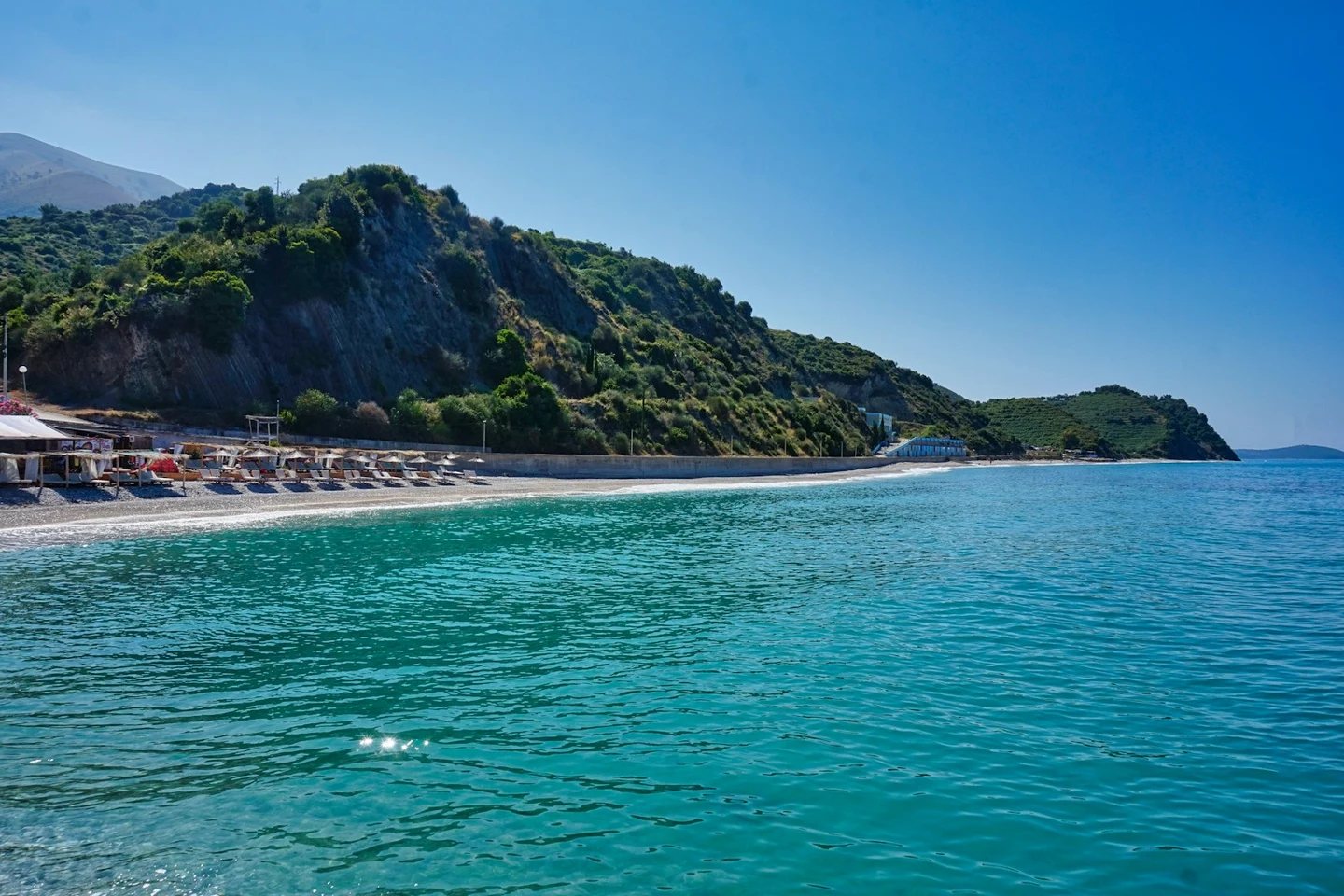 Türkisblaue Bucht der albanischen Riviera mit Kiesstrand