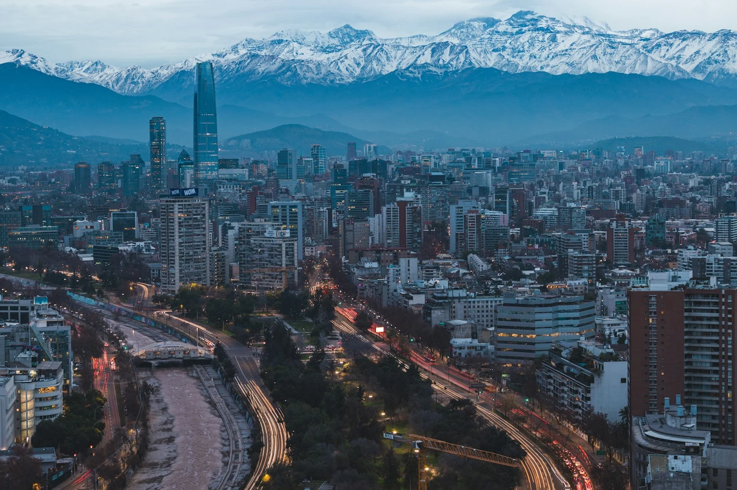 Die Skyline von Santiago de Chile vor schneebedeckten Anden in der Abenddämmerung