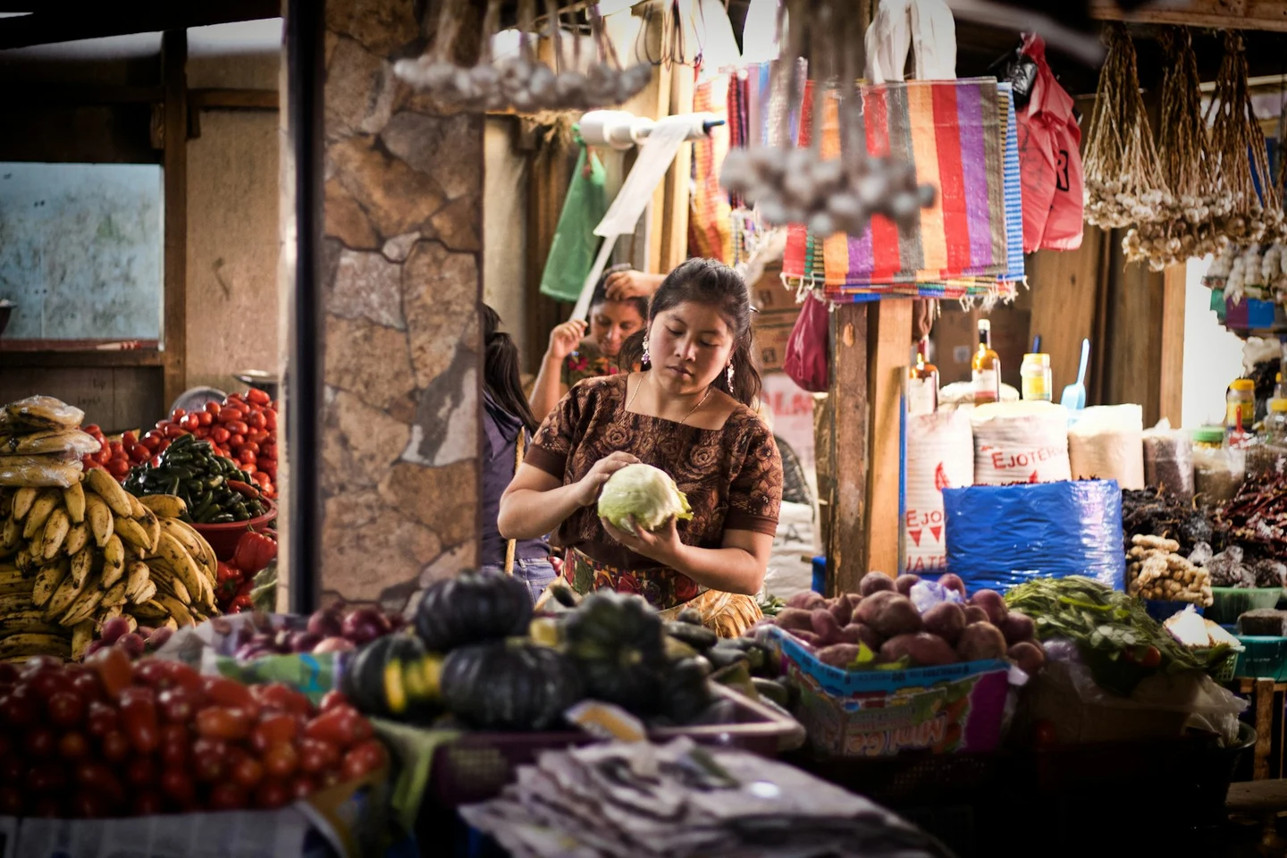 Marktstand in Guatemala mit Händlerin, Obst und Gemüse