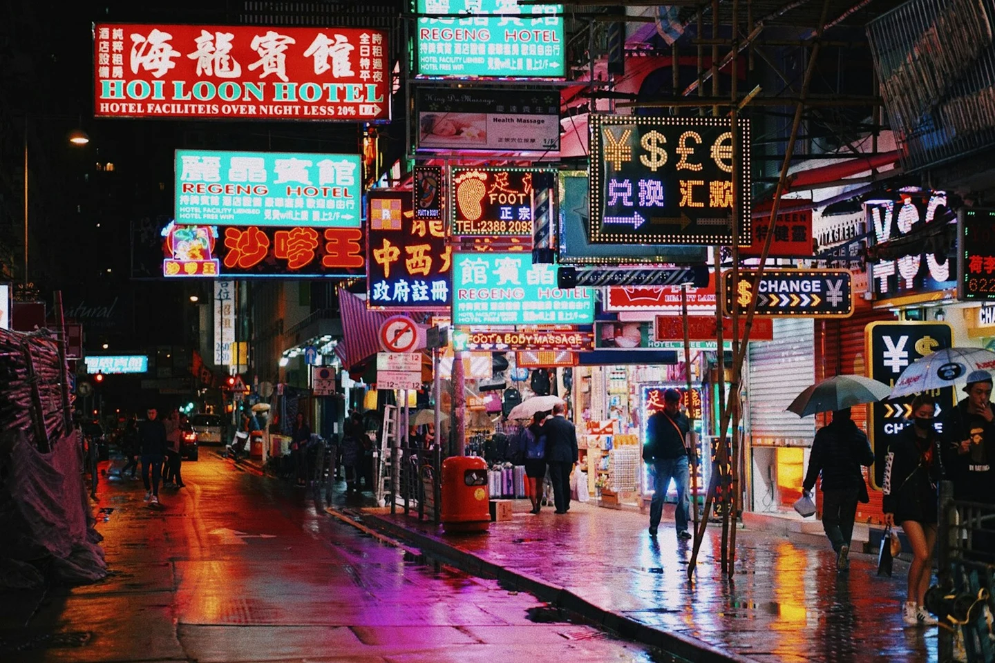 Neonschilder über einer regennassen Straße in Kowloon
