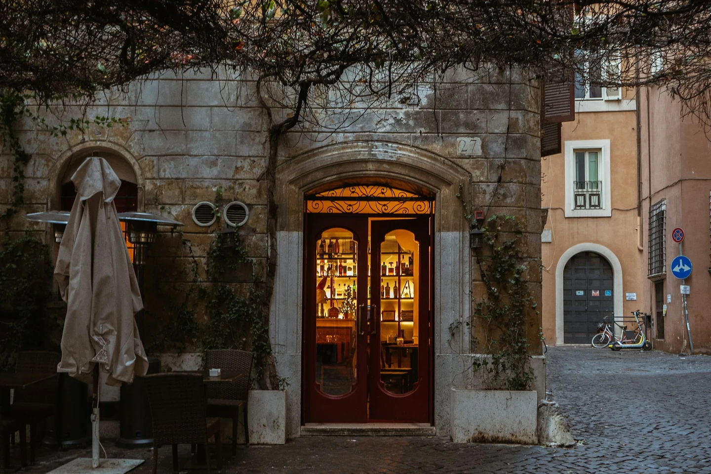 Kopfsteingepflasterte Ecke in Rom mit warm erleuchteter Bar