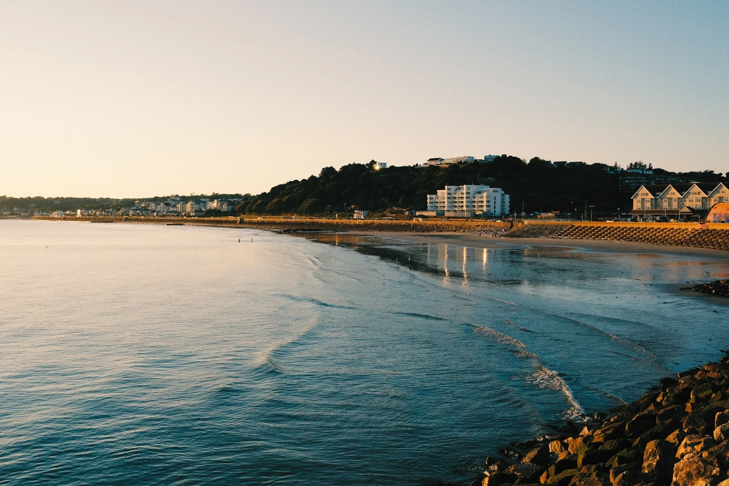 Sandbucht mit Promenade und Wohnhäusern auf Jersey im Abendlicht