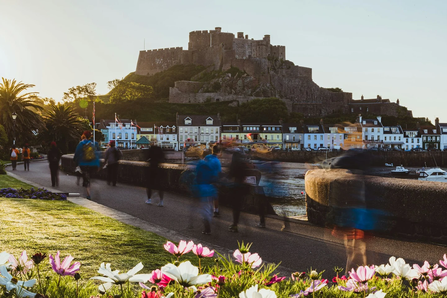 Hafenpromenade von Gorey mit bunten Häusern unter der Burg Mont Orgueil