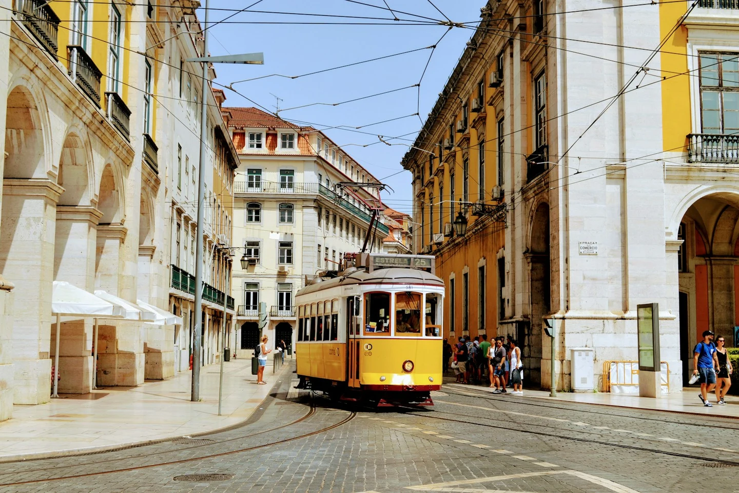 Gelbe Tram vor der Praça do Comércio in Lissabon