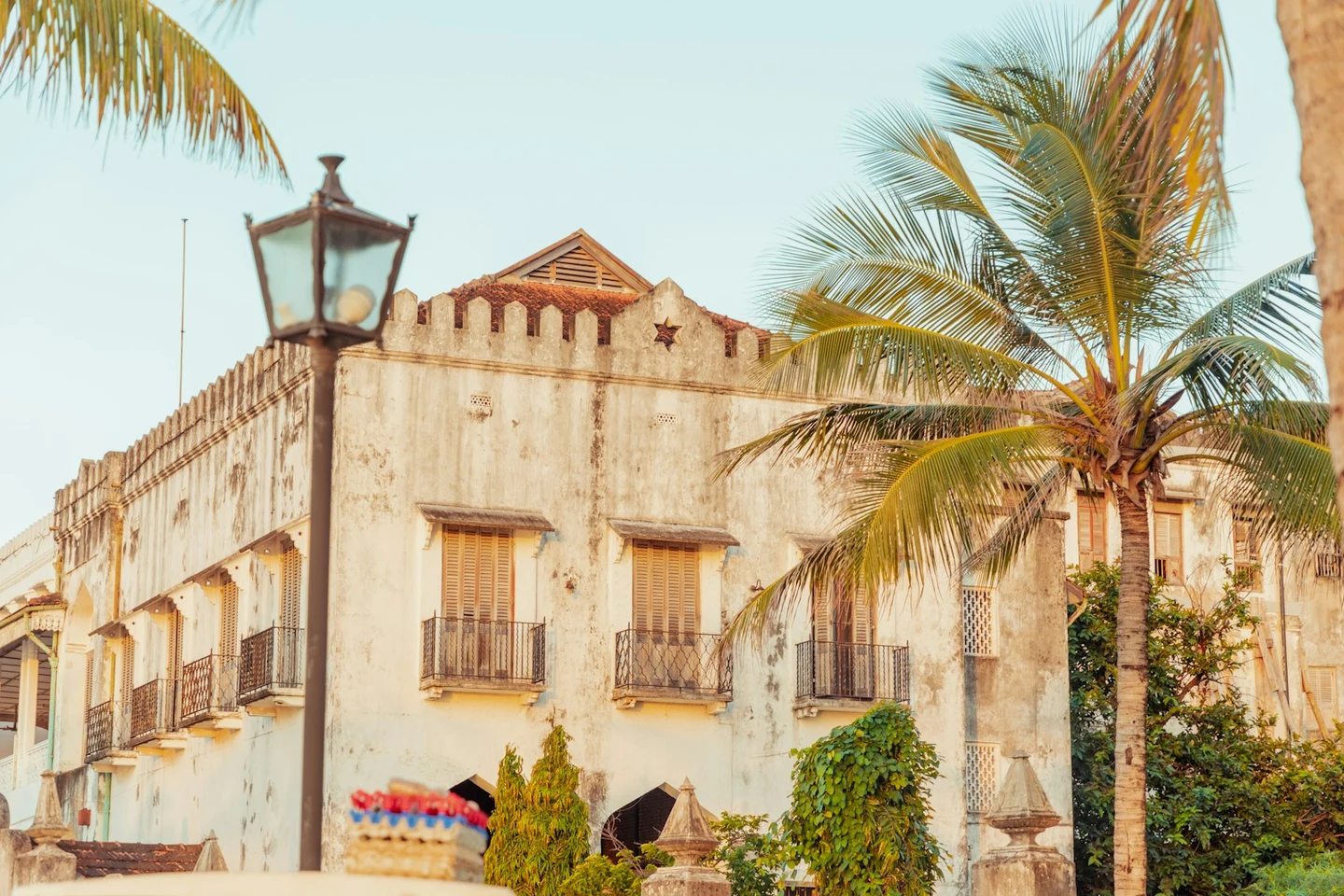 Historisches Gebäude in Stone Town mit Palmen im Abendlicht