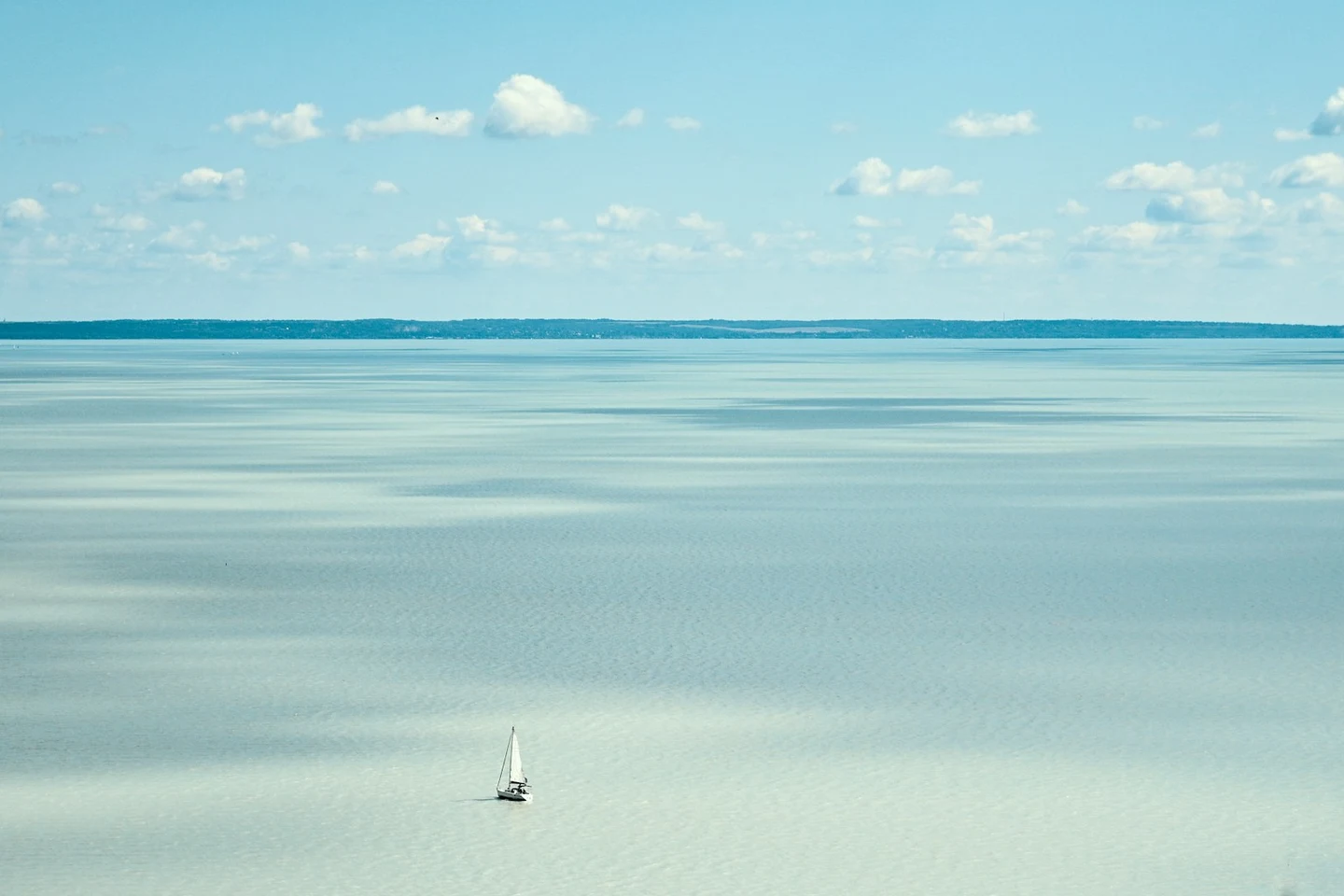 Einsames Segelboot auf dem milchig-türkisen Balaton